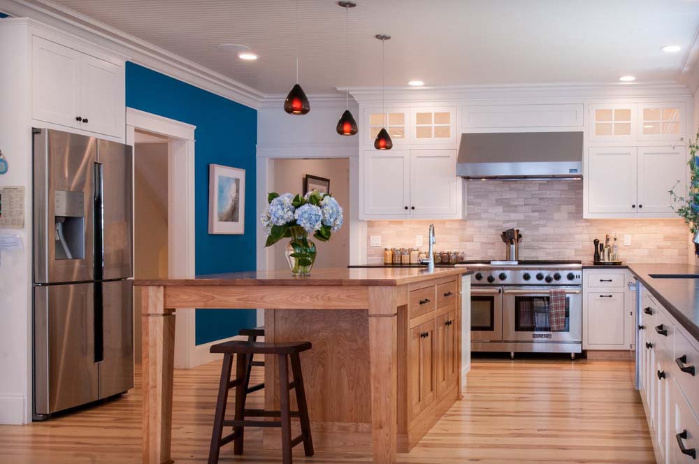 A kitchen with blue walls and wooden cabinets.