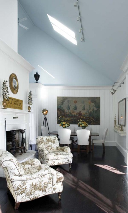 A living room with white furniture and blue walls.