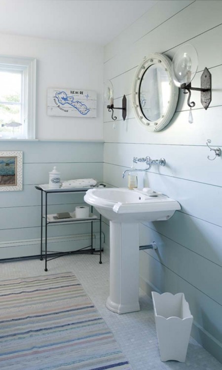 A bathroom with blue walls and white fixtures.