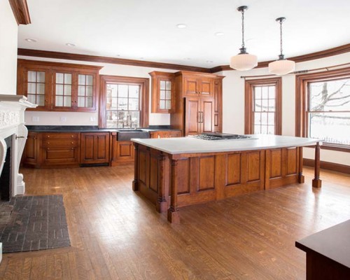 A large kitchen with wooden cabinets and floors.