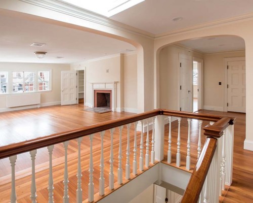 A large open living room with wood floors and white walls.