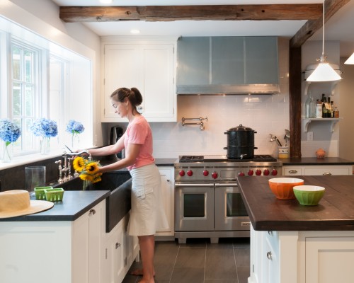 A woman in the kitchen washing dishes.