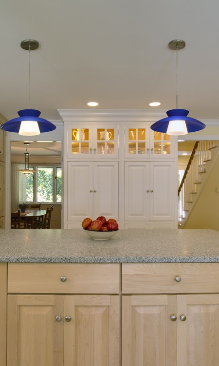 A kitchen with white cabinets and blue lights