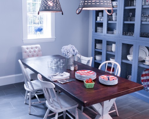 A dining room table with four chairs and two lamps.