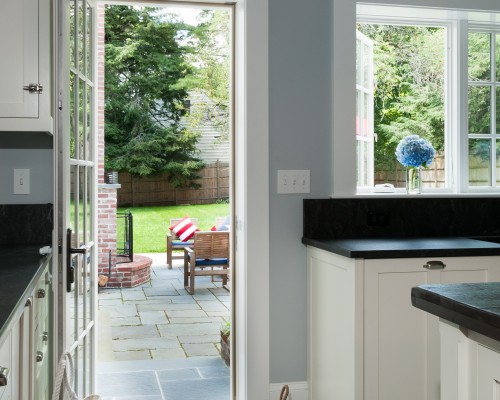 A kitchen with an open door leading to the patio.