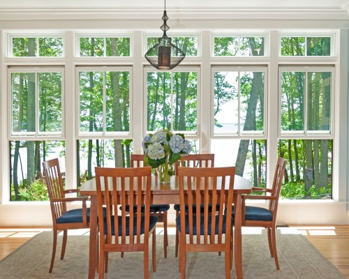 A dining room table with chairs and a chandelier.