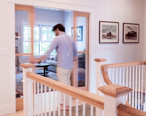 A man standing on top of stairs in front of a sliding glass door.