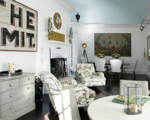 A living room with white furniture and a fireplace.