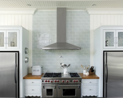 A kitchen with two refrigerators and a stove.