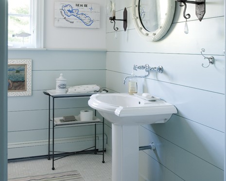 A bathroom with blue walls and white fixtures.