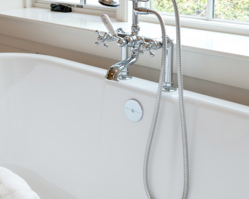 A bath tub with a shower head and faucet.