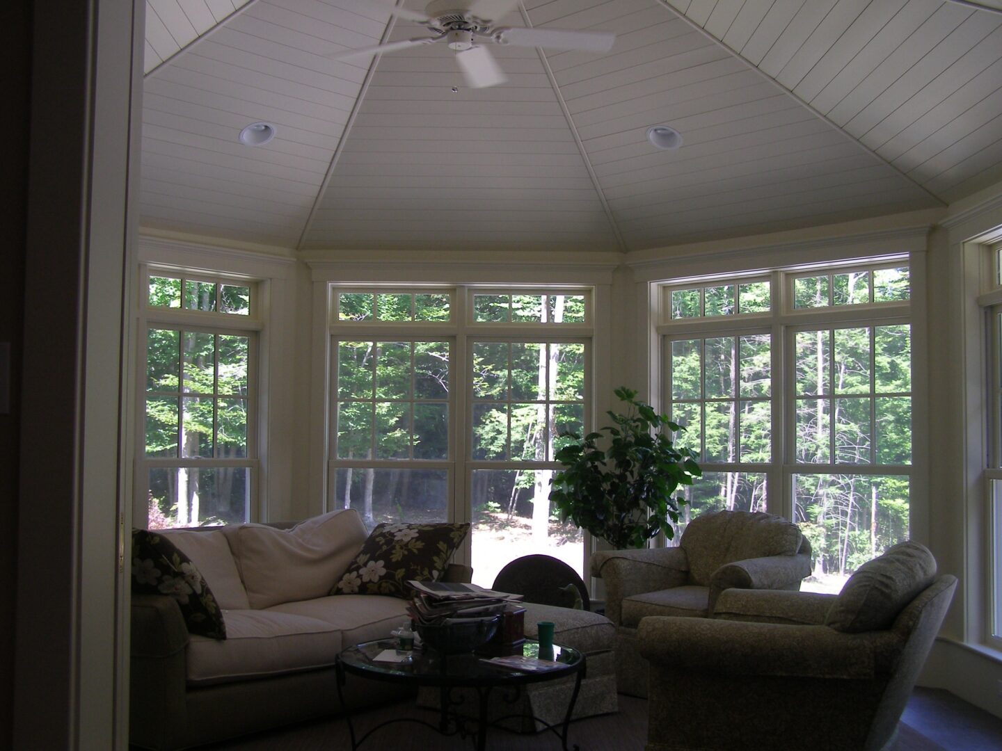 A living room with many windows and furniture