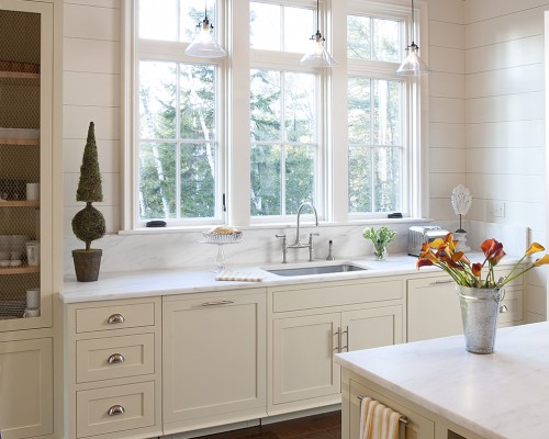 A kitchen with white cabinets and a sink.