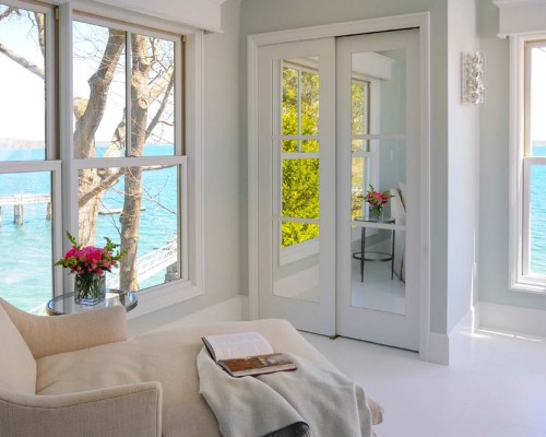 A room with a couch and a window overlooking the ocean.