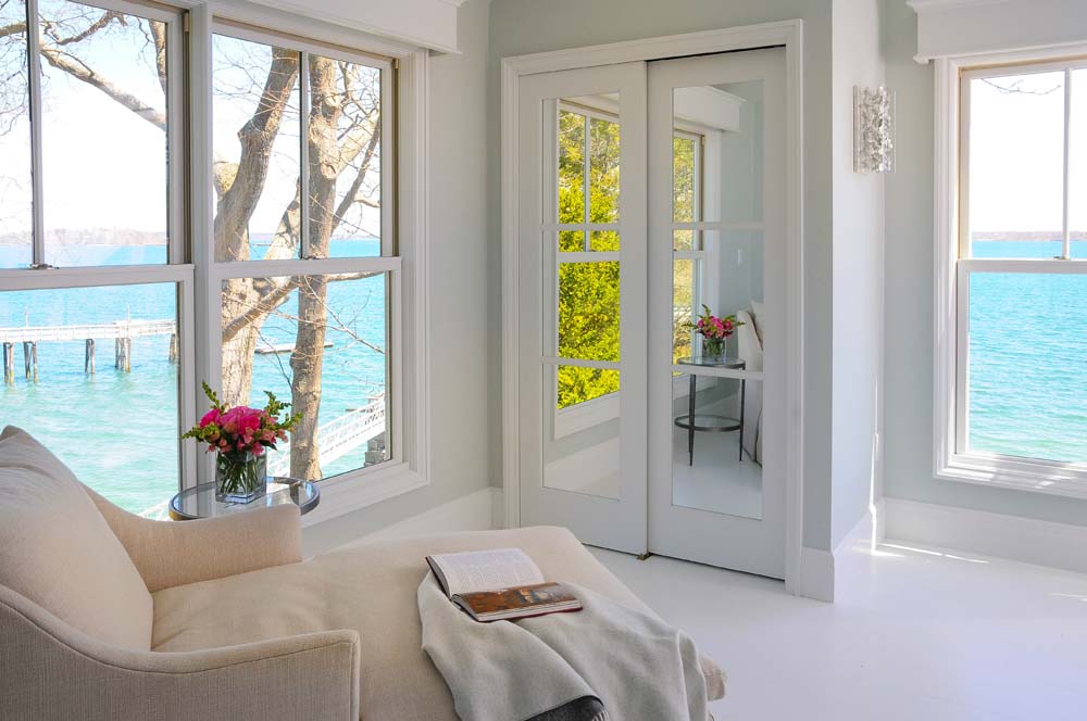 A room with a couch and a window overlooking the ocean.