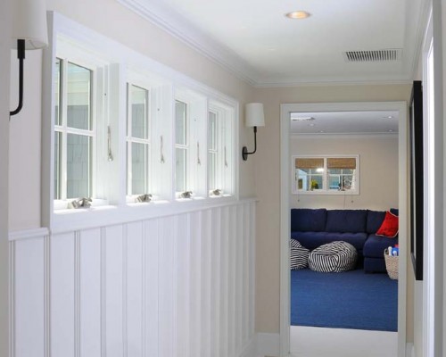 A hallway with white walls and blue carpet.