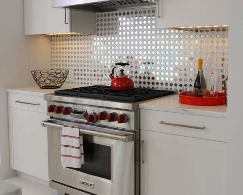 A kitchen with a stove and white cabinets