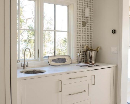 A kitchen with white cabinets and a sink.